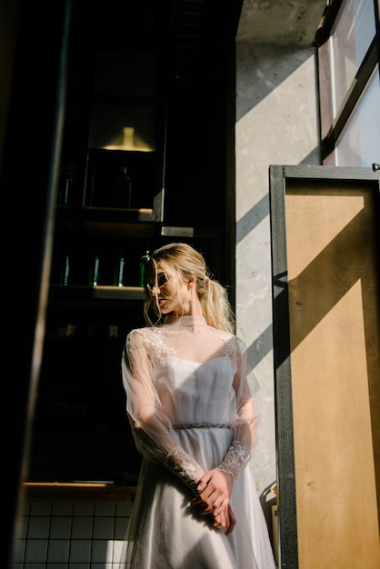 Mariée en robe de mariée blanche posant à l'intérieur