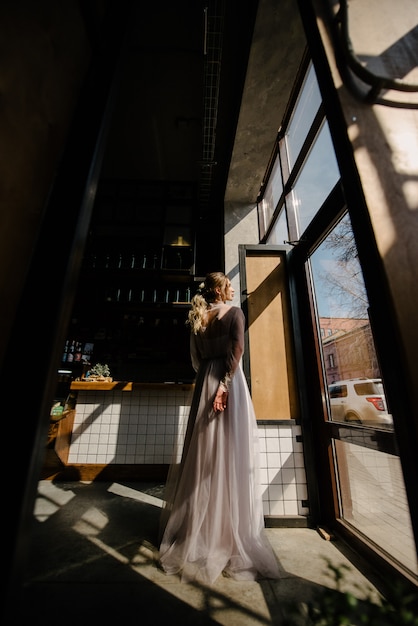 Mariée en robe de mariée blanche posant à l'intérieur