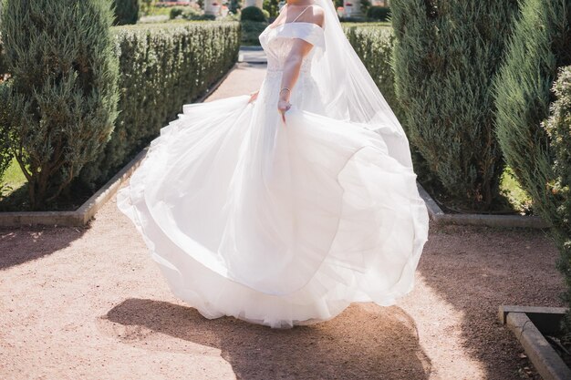 Mariée en robe de mariée et bouquet dans le parc