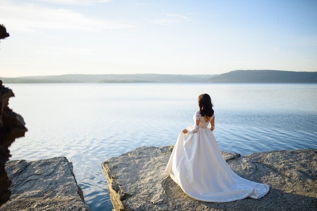 Mariée en robe de mariée près d'un lac