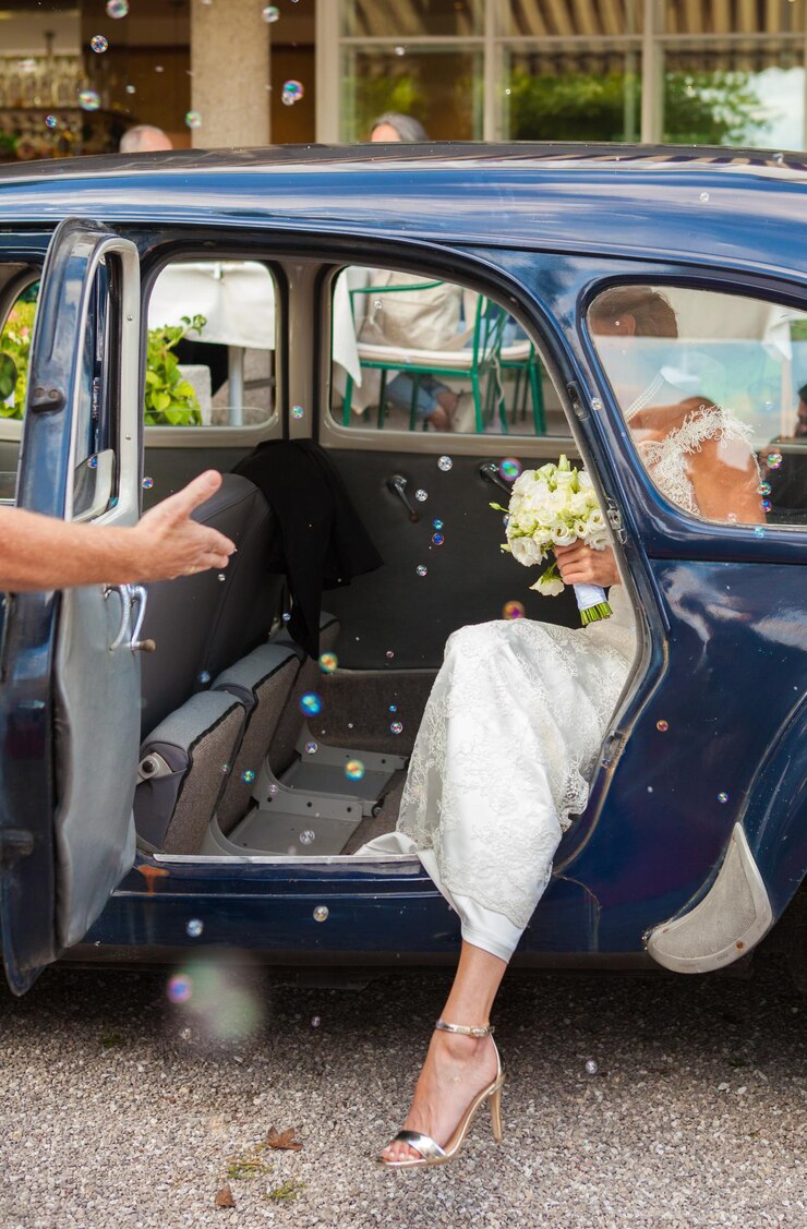 Photo la mariée sort de la voiture.