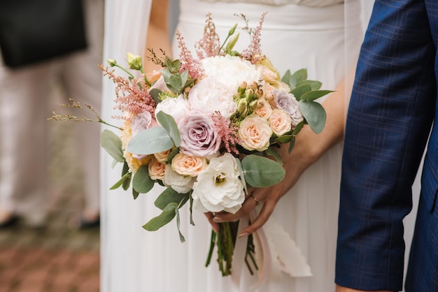 Une mariée tenant un beau bouquet de mariée. Fermer