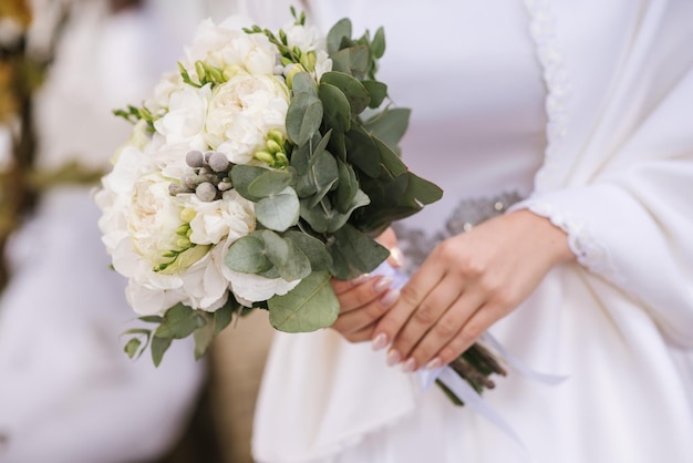 Une mariée tenant un beau bouquet de mariée. Fermer