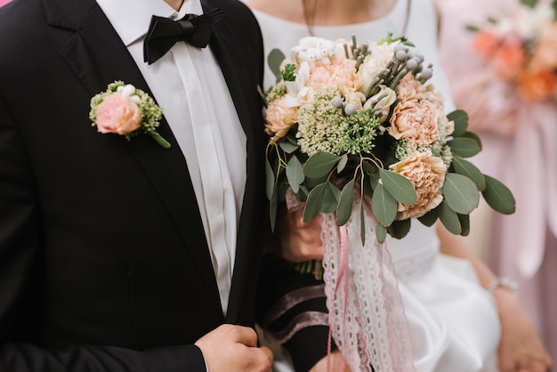 Une mariée tenant un beau bouquet de mariée. Fermer