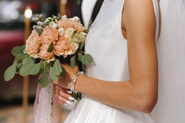 Une mariée tenant un beau bouquet de mariée. Fermer