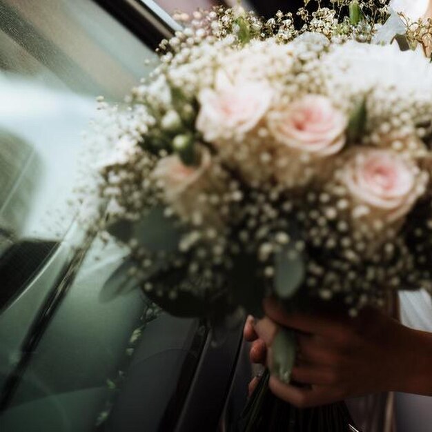 la mariée tenant un bouquet attend le moment de descendre de la voiture pour la cérémonie