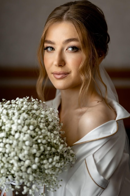 Une mariée tenant un bouquet de fleurs blanches