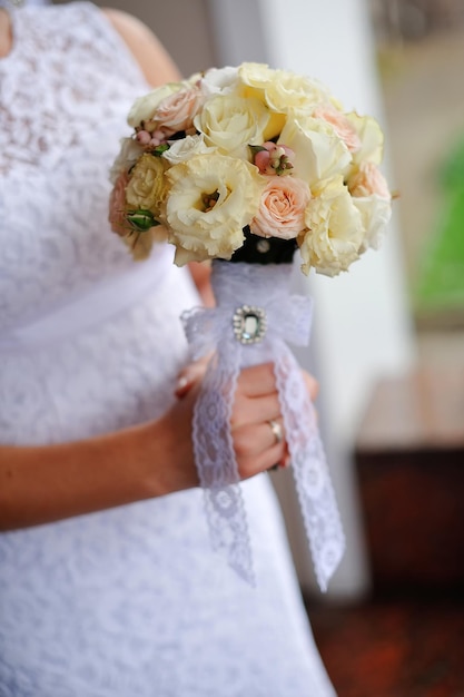 Mariée tenant le bouquet de mariage blanc