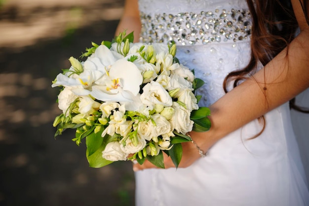 Mariée tenant un bouquet de mariage dans les mains