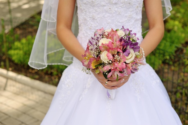 Mariée tenant un bouquet de mariage à la main