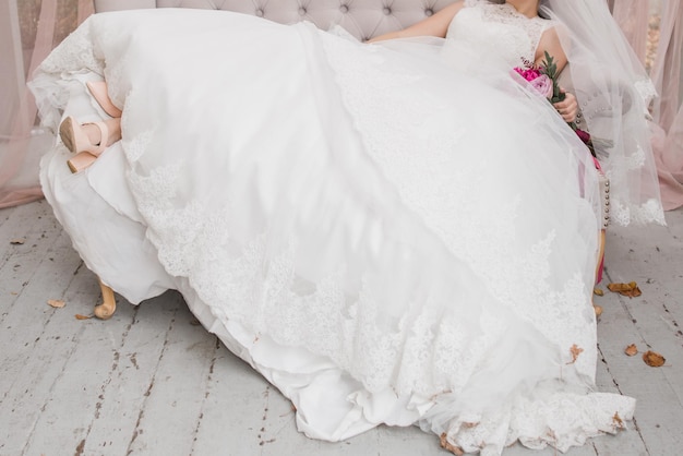 Photo mariée tenant un bouquet de mariée dans une robe