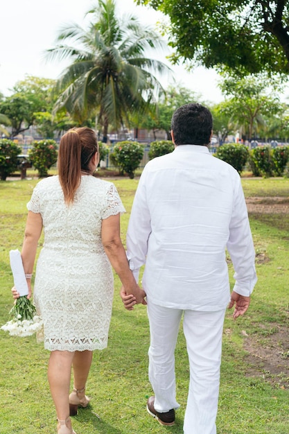 La mariée tient un beau bouquet de fleurs blanches Cérémonie du jour du mariage à l'extérieur