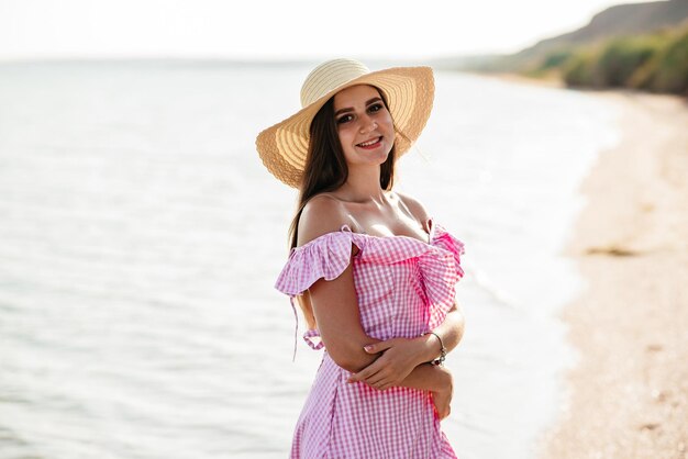 La mariée tient un beau bouquet de fleurs de mariage sur fond de mer La fille est vêtue d'une robe de mariée bleue et d'un chapeau