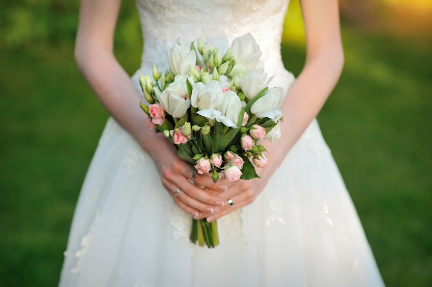 La mariée tient un beau bouquet de mariage blanc