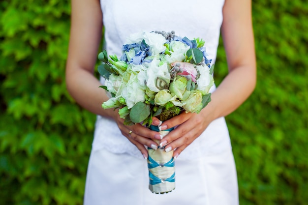 La mariée tient le beau bouquet de mariage