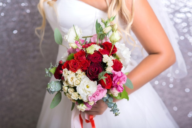 La mariée tient le beau bouquet de mariage