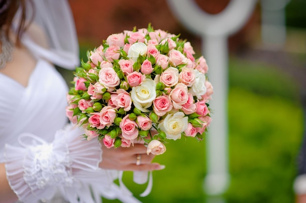 La mariée tient un beau bouquet de mariage