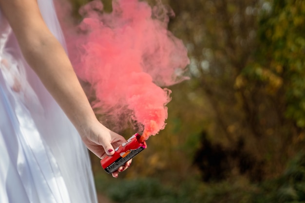 La mariée tient une bombe fumigène dans ses mains, le concept de relations familiales