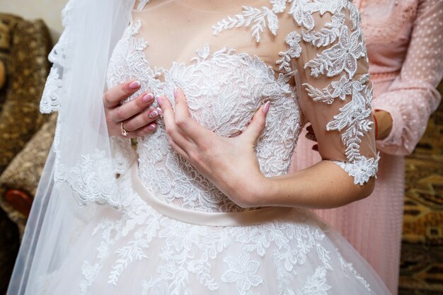 La mariée tient dans ses mains une belle robe de mariée