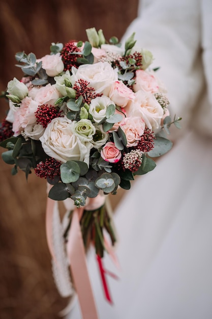 La mariée tient un délicat bouquet de fleurs dans ses mains 4338