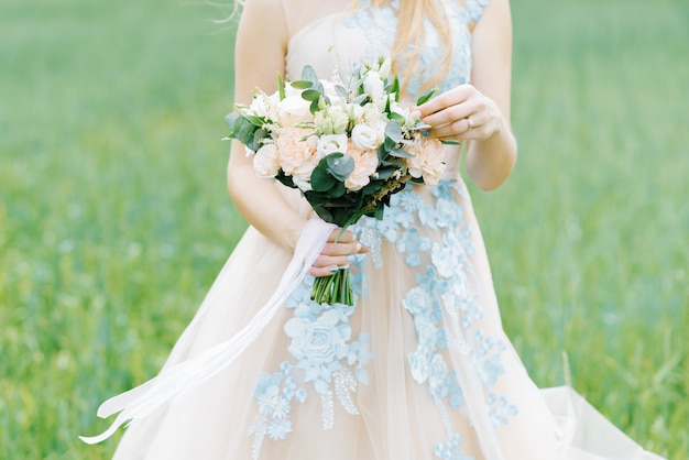 La mariée a touché sa main à un bouquet délicat et beau