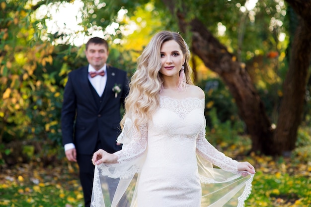 Mariée avec voile et marié dans le jardin