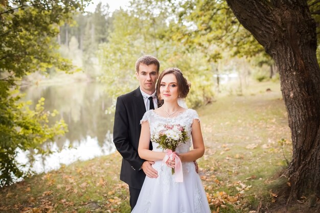 Les mariés s'embrassent dans le parc d'automne