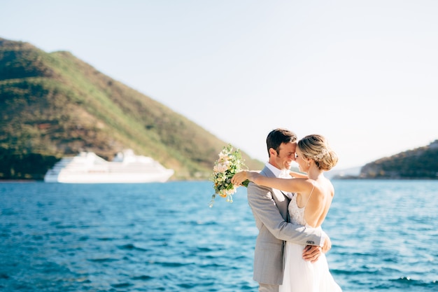 Les mariés s'embrassent sur la jetée de la baie de Kotor