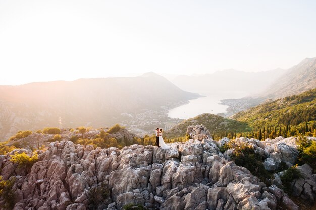 Les mariés s'embrassent sur le mont Lovcen, une vue panoramique pittoresque sur la baie de Kotor