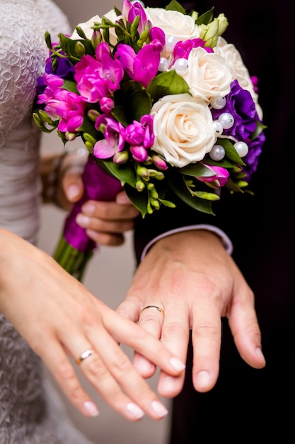 les mariés se tenant la main avec un bouquet