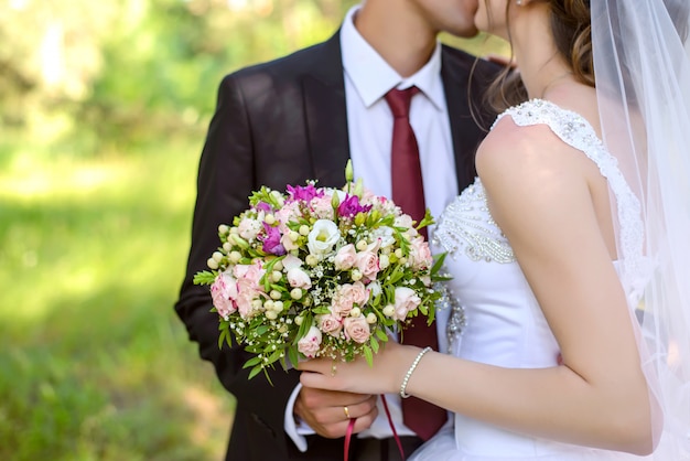 Les mariés tenant le bouquet de mariée