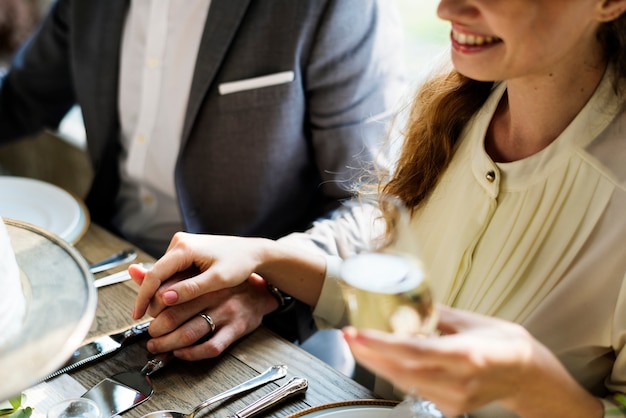 Les mariés tenant les mains sur la réception de mariage