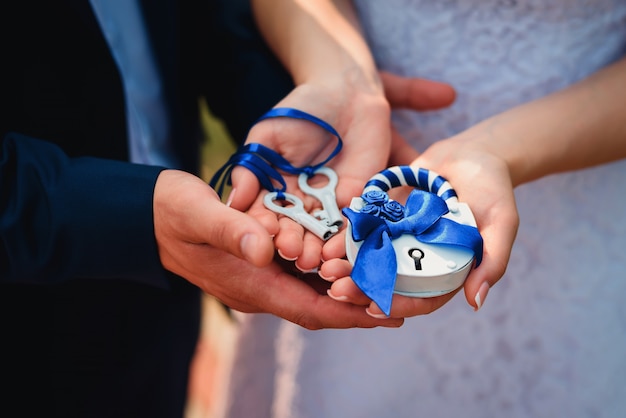 Les mariés tiennent un cadenas et des clés. Tradition de mariage russe pour consolider la relation