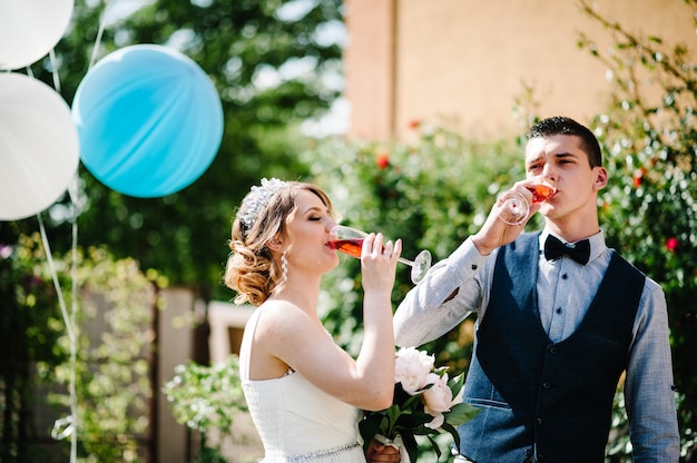 Les mariés tiennent dans les mains un verre de champagne, boire.