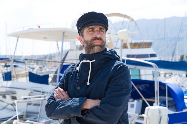 Marin dans le port de plaisance avec fond de bateaux