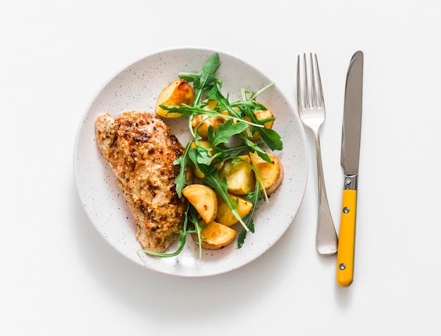 Marinade au yogourt grec à la moutarde dinde au four et salade de roquette aux pommes de terre nouvelles sur fond clair vue de dessus