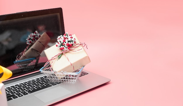 Marketing en ligne, ordinateur portable concept Krismas avec des cadeaux, sur fond rose, bannière, espace copie