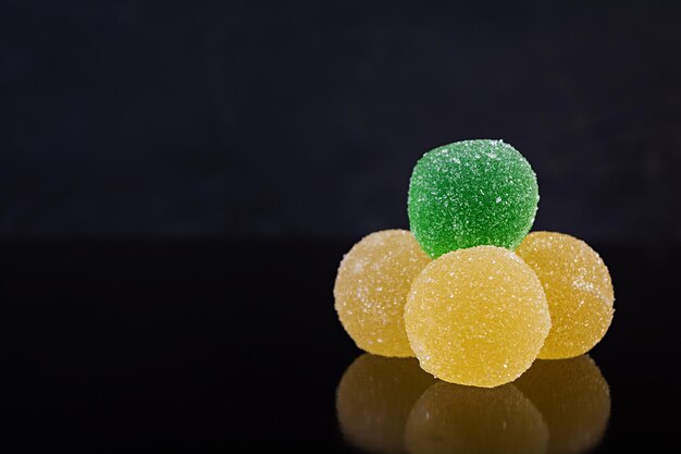 Photo une marmalade colorée isolée sur un fond sombre des boules de jujube délicieuses