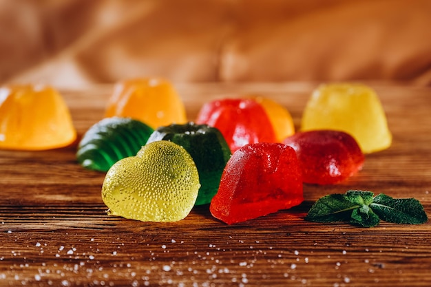 La marmelade de fruits multicolores se trouve sur une table en bois