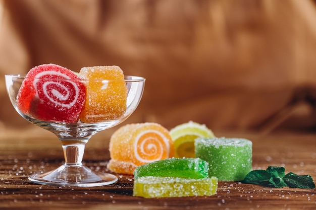 La marmelade de fruits multicolores se trouve sur une table en bois