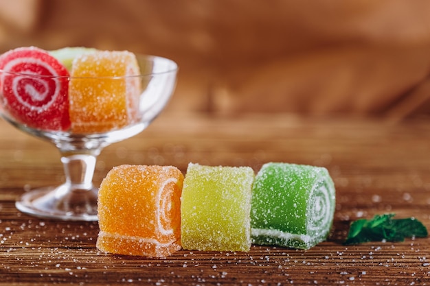 La marmelade de fruits multicolores se trouve sur une table en bois