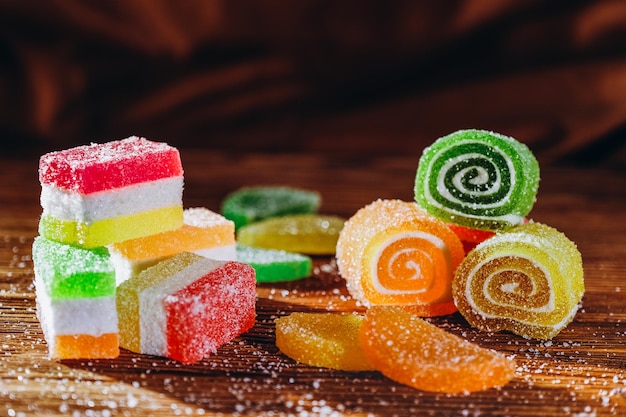 La marmelade de fruits multicolores se trouve sur une table en bois