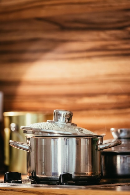 Photo marmite en métal à la vapeur dans le bois de la cuisine