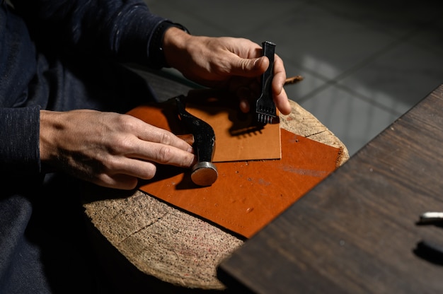 Un maroquinier travaille à la tannerie