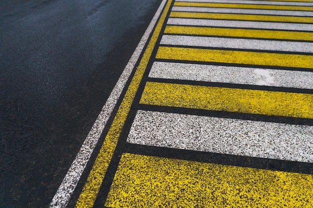 Marquage routier sur asphalte mouillé Zèbre jaune blanc pour la sécurité des piétons Traversement piétonnier Une place de copie