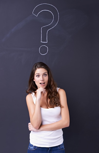 Marque d'interrogation surprise et portrait d'une femme avec une idée brainstorming et demandant pourquoi par tableau noir Questions de pensée et personne avec un emoji de choc et un symbole sur fond noir pour la solution