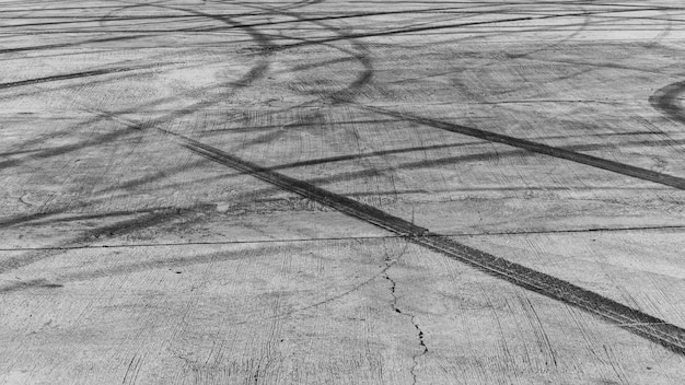 Marque de pneu sur asphalte sur route, texture et fond de la piste de course, fond noir abstrait