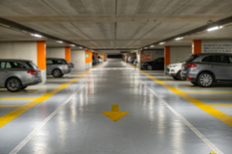 Photo marques jaunes avec des voitures modernes floues garées à l'intérieur d'un parking souterrain fermé.