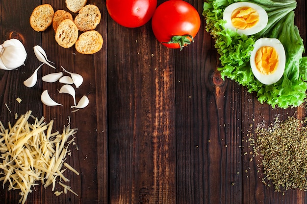 Marron en bois avec épices sel fromage oeufs salade tomates craquelins ail