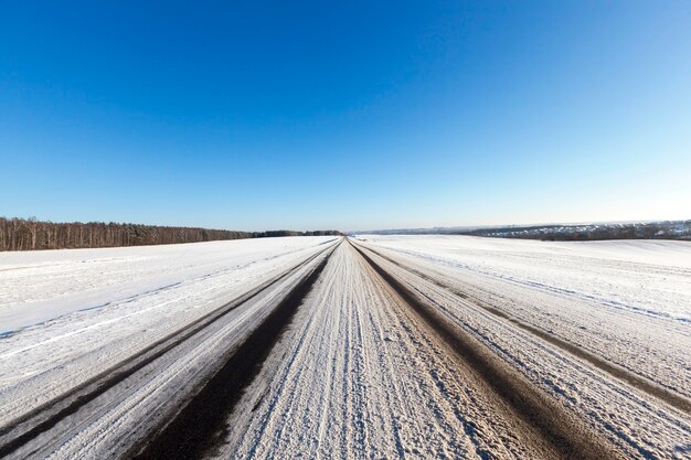Marron neige sale, allongé sur la route en hiver